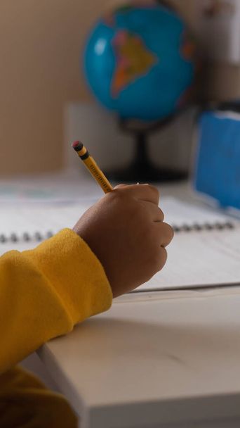 A vrtical shot of a child studying at home - Foto, Imagem