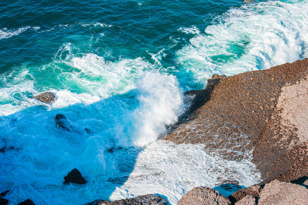 Egy óceán hullámai zuhannak a szikláknak. - Fotó, kép