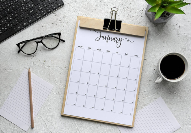 A flat lay of the calendar of January, glasses, coffee and other objects for working -  background - Photo, image