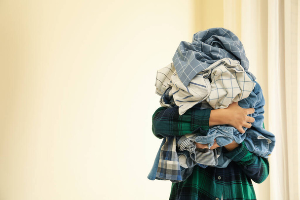 Žena drží hromadu zmačkaného prádla, prostor pro text - Fotografie, Obrázek