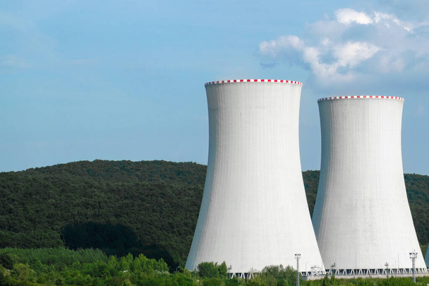 Zwei Schornsteine eines Atomkraftwerks in der Nähe der Straße.  - Foto, Bild