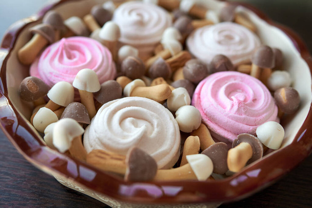 Prosty talerz świąteczny z kwiatów różanego i białego pianki oraz brązowo-białe ciasteczka w postaci grzybów z czekoladowymi czapkami - Zdjęcie, obraz