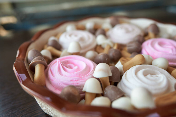 Простое рождественское блюдо из розового и белого зефира и коричнево-белого печенья в виде грибов с шоколадными колпачками - Фото, изображение
