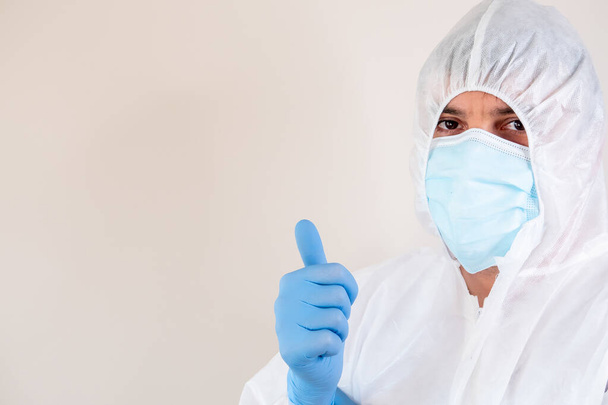 A male doctor with PP protective suit posing against gray background - Foto, imagen