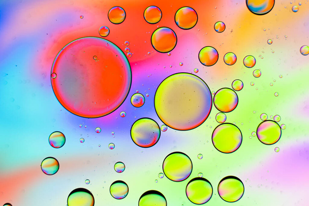 A macro shot of different sized bubbles on a colorful background - Valokuva, kuva