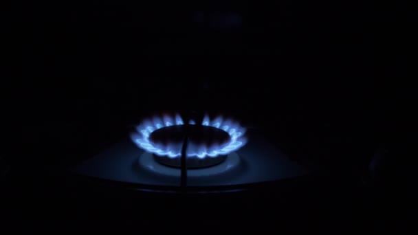 Quemador de gas encendido, que brilla con llama azul, por la noche en la cocina. Primer plano - Metraje, vídeo