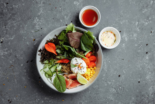 fresh healthy light breakfast, business lunch. Breakfast with poached egg, buckwheat, red fish, fresh salad, cucumbers, business lunch concept - Foto, Imagen