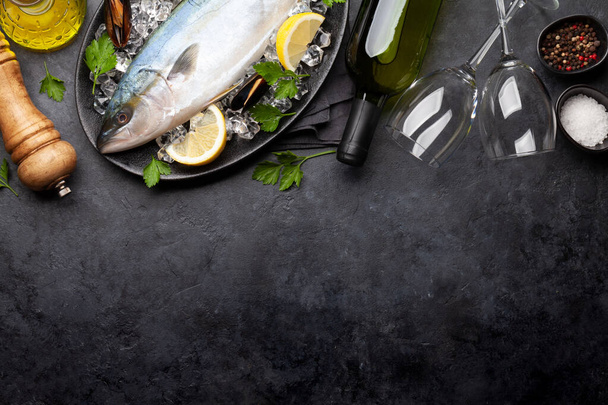 Cocinar pescado crudo. Mariscos y vino blanco sobre mesa de piedra. Vista superior plano con espacio de copia - Foto, Imagen