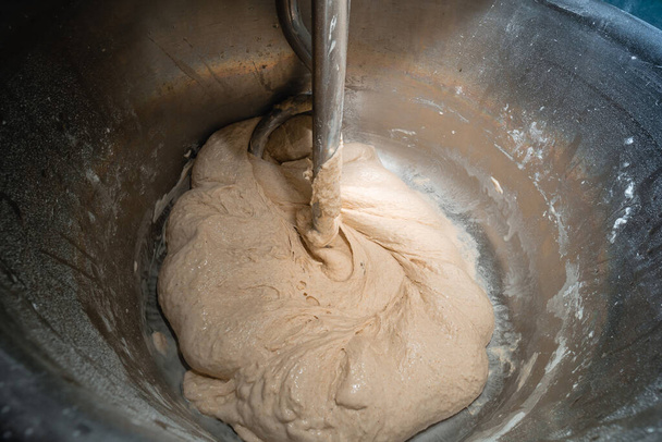 パン焼き菓子を作る過程。生地、小麦粉、水を混練。工業用ミキサー、自動。景色は近い. - 写真・画像