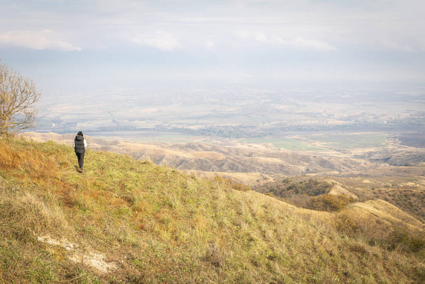 Female person walks on the black mountain with panoramic views of vashlovani national park - Photo, Image