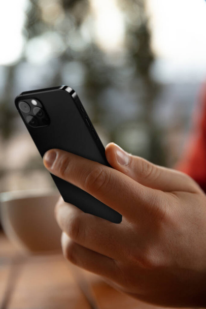 Mužské ruce drží nový model chytrého telefonu. Koncept sociálních médií. - Fotografie, Obrázek