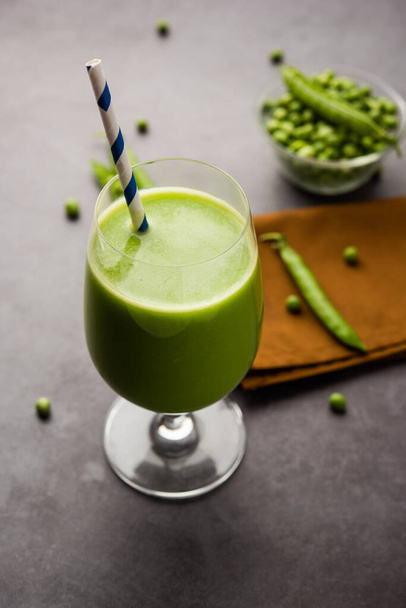 Πράσινο Μπιζέλια Φρέσκος χυμός ή smoothie ή ποτό που παρασκευάζεται χρησιμοποιώντας watana ή vatana, ινδικό υγιεινό πράσινο ρόφημα σερβίρεται σε ένα ποτήρι - Φωτογραφία, εικόνα