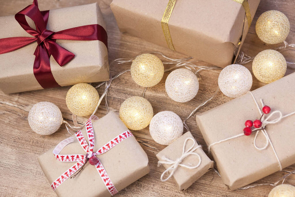 Рождественский фон с подарочными коробками, гирлянда на деревянном фоне - Фото, изображение