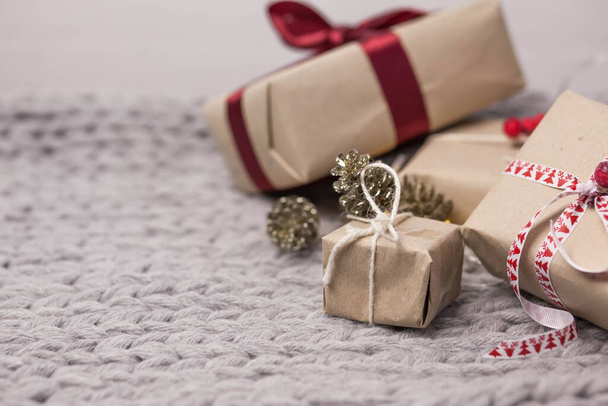 Sfondo di Natale con scatole regalo, coni su sfondo lavorato a maglia - Foto, immagini