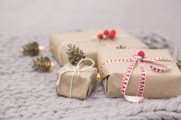 Sfondo di Natale con scatole regalo, coni su sfondo lavorato a maglia - Foto, immagini