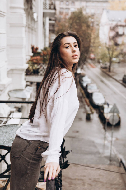 Photoshoot of a beautiful girl in a white shirt on the balcony - Fotoğraf, Görsel