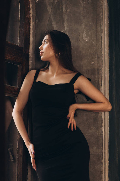 Divat fotózás egy fotó stúdióban egy gyönyörű lány fekete ruhában - Fotó, kép