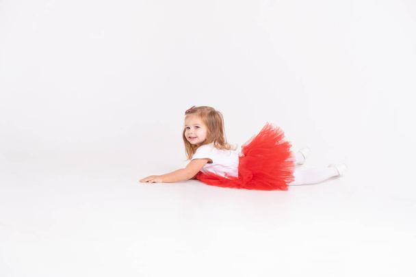 toddler girl in red skirt and white t-shirt on white background. Valentine Day concept - Foto, imagen