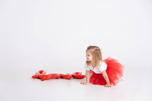 cute toddler girl with the inscription love from balloons on a white background. Valentines day - Photo, Image
