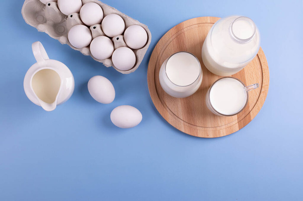white eggs and milk as calcium concept. minimalism style. - Fotó, kép