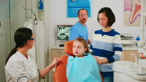Doktor çocuğa doğru diş hijyenini gösteriyor. Diş iskeletinin maketini kullanarak. - Video, Çekim