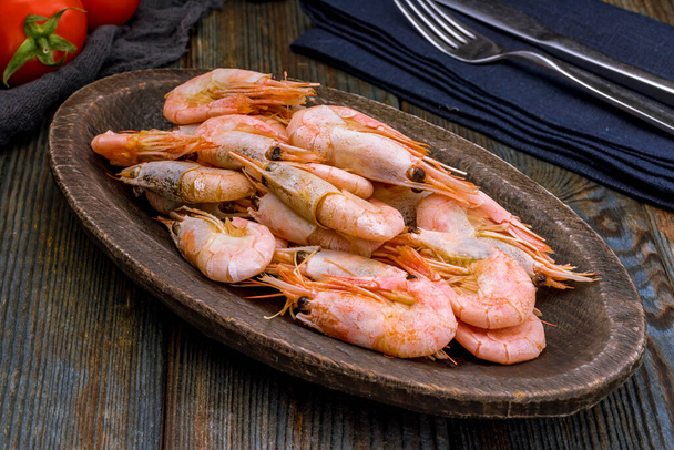 boiled shrimp on ice on dark blue table - Foto, afbeelding