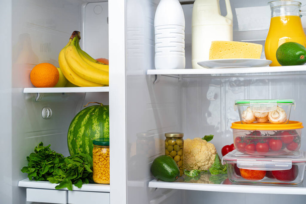 Open fridge full of fruits, vegetables and drinks - Fotó, kép
