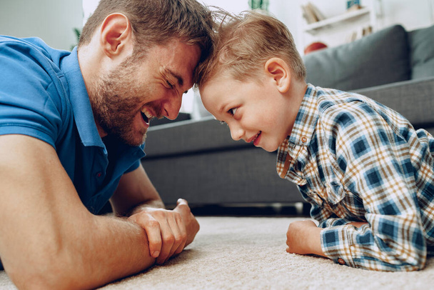 Father and son playing together on carpet at home - Foto, Imagem