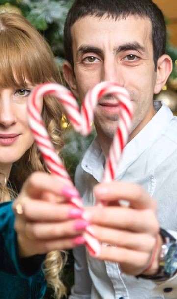 Christmas lollipops in the hands of a man and a woman. Selective focus. Holiday. - Photo, Image
