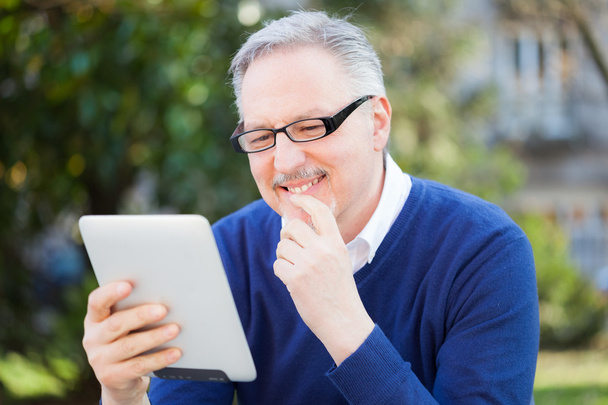 Senior man using a tablet - Foto, afbeelding