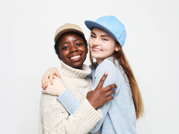 Multi-ethnic two young women with dark and white skin color female women portrait. Hipster style. Friendship and lifestyle concept. - Foto, afbeelding