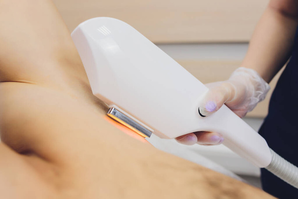 man receiving laser epilation at armpit on beauty center. - 写真・画像