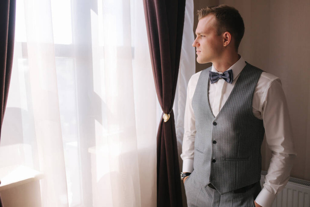 Handsome groom dressed in hotel. Wedding day - Photo, Image