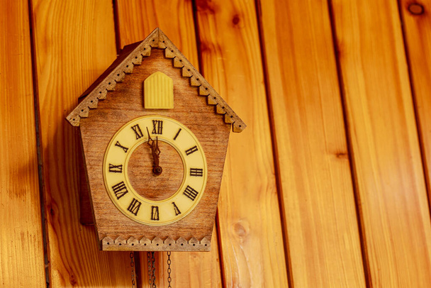 Годинник "Куку" з римськими цифрами на дерев'яній стіні. Поставте текст. Скоро північ. - Фото, зображення