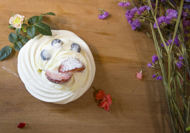 Anna Pavlova taart meringue met fruit en bloemen - Foto, afbeelding