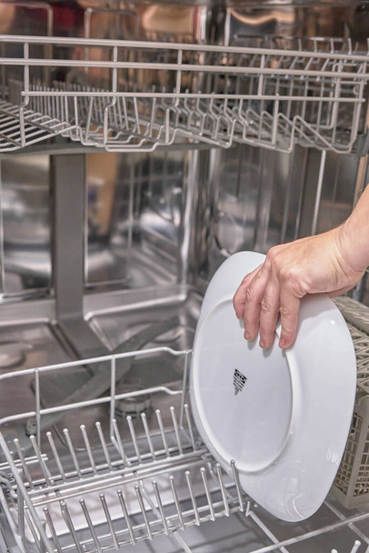 Geschirr und Gläser in die Spülmaschine stellen - Foto, Bild