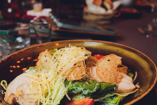 Caesar salad with chicken and greens on wooden table. - Valokuva, kuva
