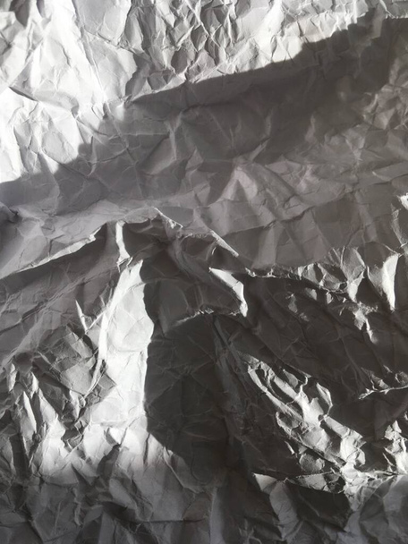 Una hoja rota y muy arrugada de papel gris. Abstracción - Foto, Imagen