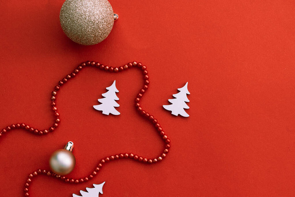 Χριστουγεννιάτικα στολίδια με μπάλες και κόκκινο φόντο, λευκό έλατο δέντρο - Φωτογραφία, εικόνα