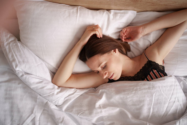 Houkutteleva nuori nainen nukkuu hyvin sängyssä - Valokuva, kuva