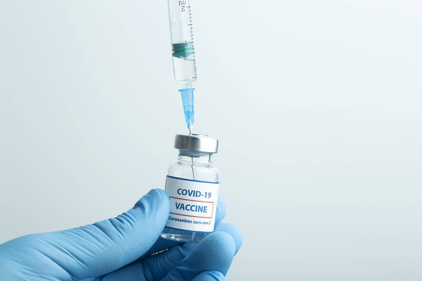Rokote COVID-19:ää vastaan. Lasiset nestemäiset lääkepullot. Ampullit, joissa on koronavirusrokote lääketieteellisessä lasipöydässä - Valokuva, kuva