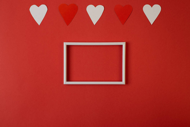 Hearts composition. Photo frame, red and white hearts on red background. Valentines day concept. Flat lay, top view, copy space - Fotoğraf, Görsel