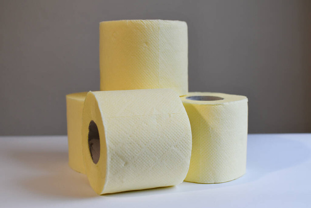 Una pila de cuatro rollos de papel higiénico desechables amarillos. Esenciales. Copiar espacio. Algodón fresco y suave. Poder adquisitivo. Vista lateral. - Foto, Imagen