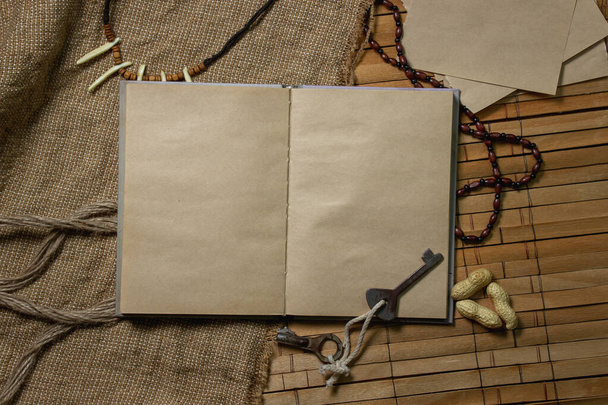 An empty book. There is a place for an inscription or logo. Book with old paper. Book on a wooden surface - Foto, Imagen
