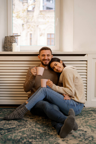 Романтическая счастливая молодая пара наслаждается отдыхом дома улыбаясь - Фото, изображение