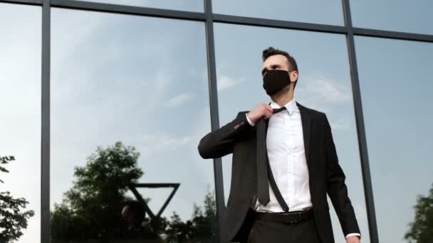 スーツの男はネクタイを緩め、顔から黒いマスクを外し、深呼吸をする。隔離後に新たな深呼吸をする. - 映像、動画