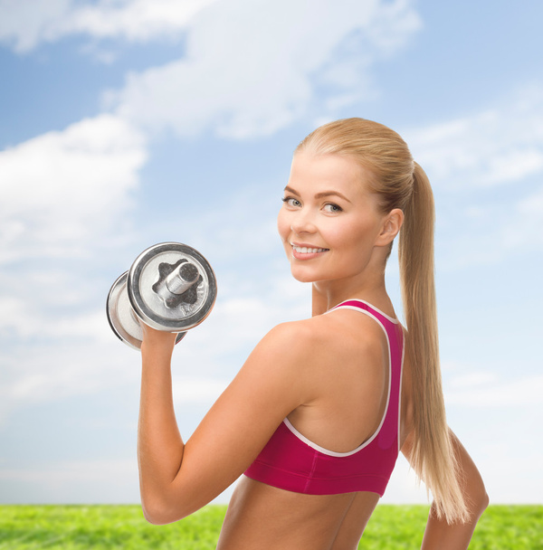 Smiling woman with heavy steel dumbbell - Foto, Imagen