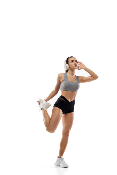 Caucasian professional female runner, athlete training isolated on white studio background. Copyspace for ad. - Фото, изображение