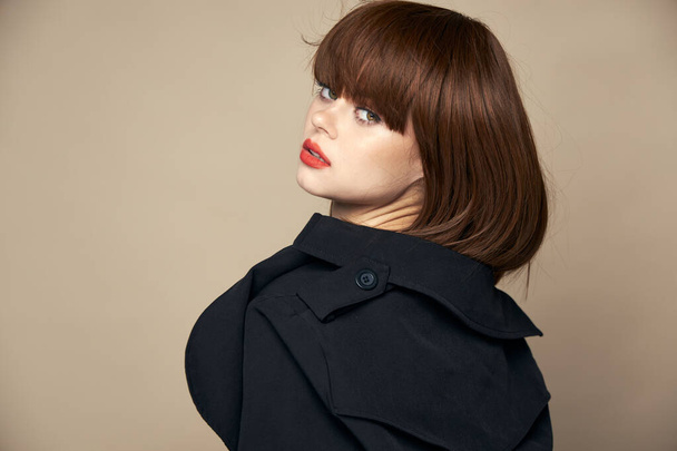 Luxusní brunetka černý kabát atraktivní vzhled s úsměvem uvnitř  - Fotografie, Obrázek
