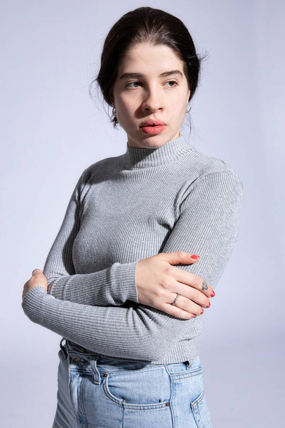 White girl in roll neck with folded arms isolated on grey - Foto, Bild